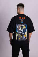 Person, die ein schwarzes Falkenstern-T-Shirt mit Falkenmotiv auf dem Rücken vor einem einfarbigen Hintergrund trägt