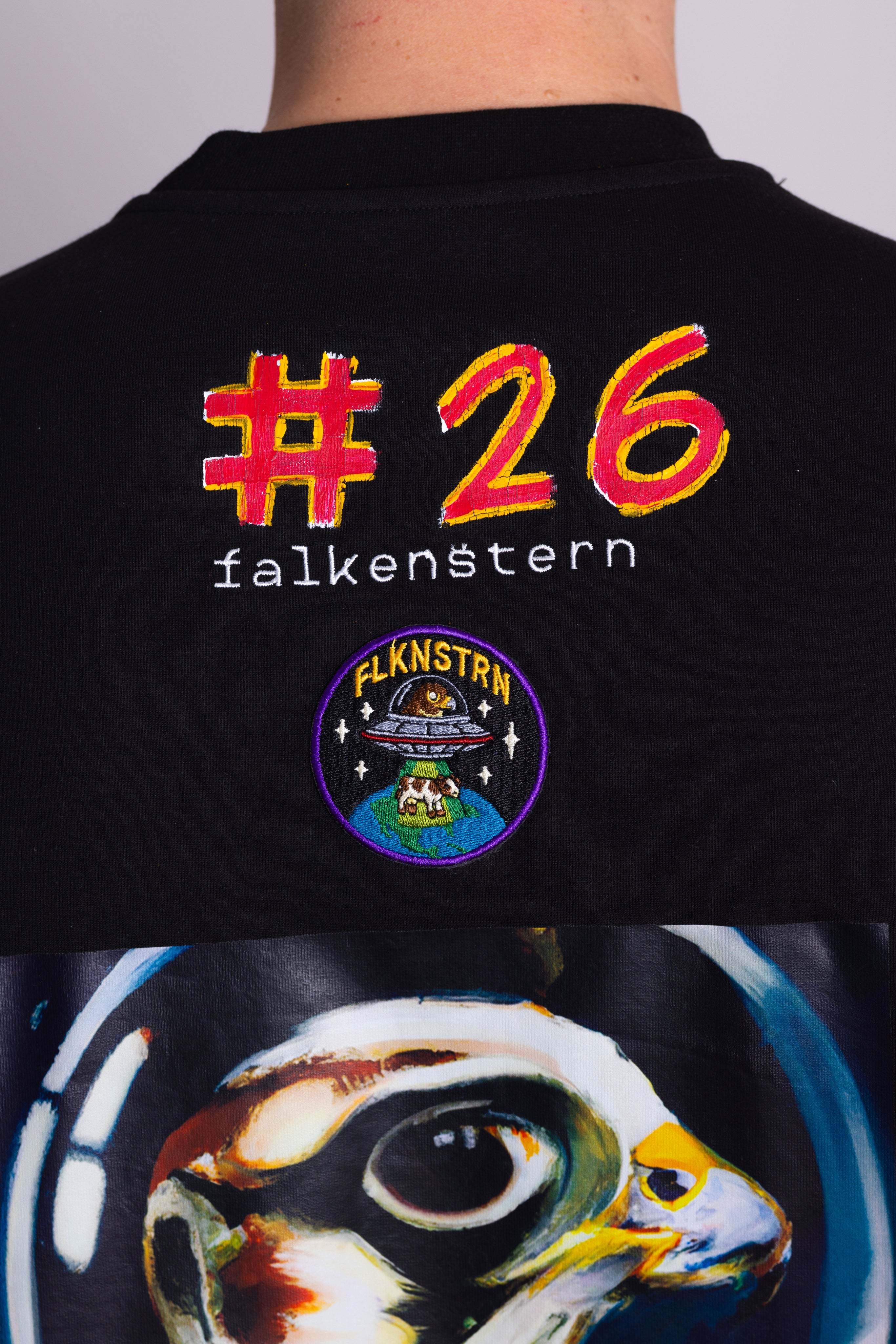 Schwarzes T-Shirt mit farbenfrohem Text und Grafikdesign auf der Rückseite